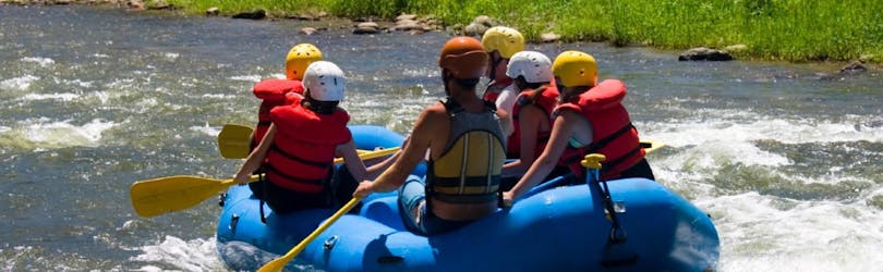 Een groep vrienden zit in het vlot en gaat de rivier af tijdens het raften op de Iller voor jeugdgroepen met MB Events & Adventures Allgäu & Bodensee.
