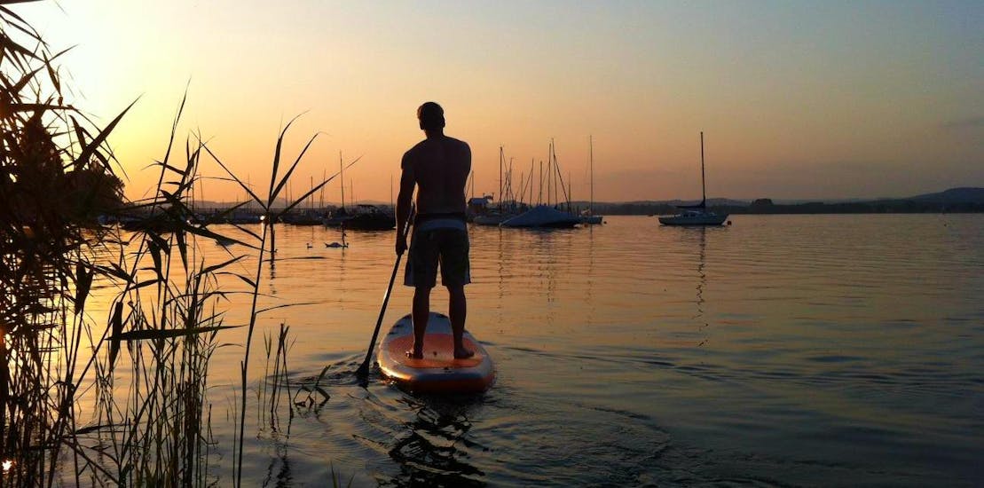 A person enjoying the sunset while Stand-Up-Paddleboarding on Lake Constance with MB Events & Adventures Allgäu & Bodensee.