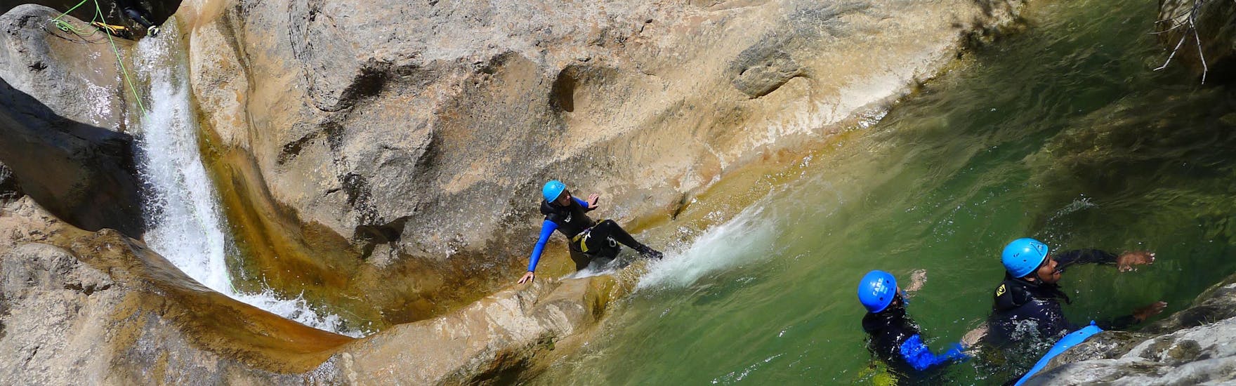 Une fille fait de la descente en rappel dans le Canyon d'Arlos lors de la découverte du Canyoning avec H2O vives.