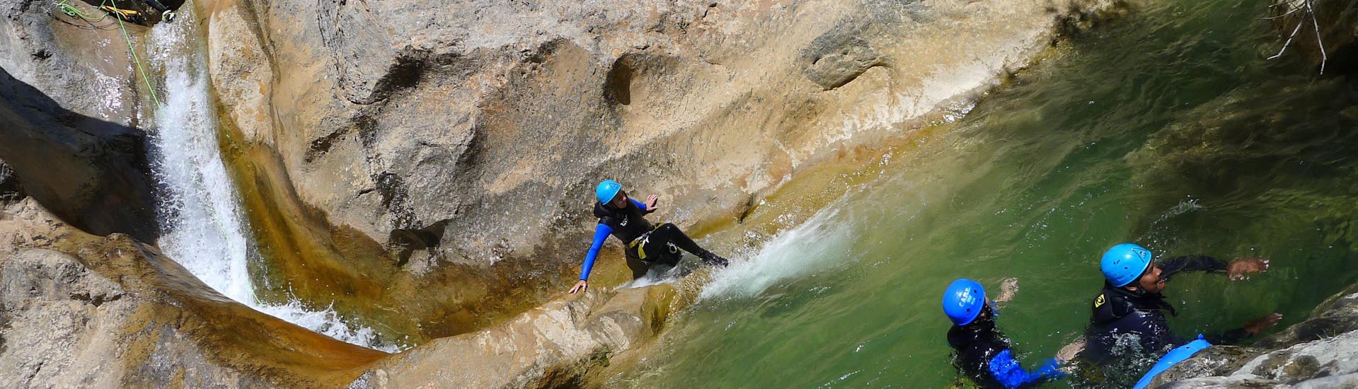 Une fille fait de la descente en rappel dans le Canyon d'Arlos lors de la découverte du Canyoning avec H2O vives.