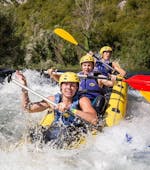 Tres amigos se divierten remando en un rápido durante el rafting en el río Cetina, con Adventure Dalmatia.
