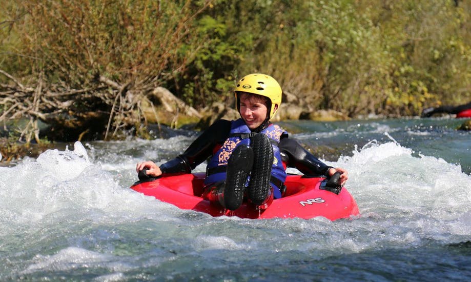 Ein Junge treibt bei dem von Adventure Dalmatia organisierten Rivertubing auf der Cetina mit einem Reifen auf dem Fluss.