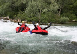 Two participants of the Rivertubing on Cetina River with City-Transfer from Split organized by Adventure Dalmatia are having fun as they pass through splashing rapids on their tubes.