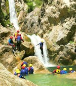 Un partecipante del Canyoning per principianti con transfer dalla città di Split organizzato da Adventure Dalmatia si trova sotto una cascata nel canyon.