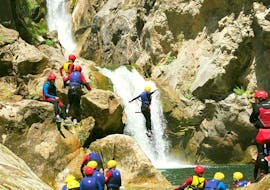 Ein Teilnehmer des von Adventure Dalmatia organisierten Canyoning für Einsteiger mit City-Transfer ab Split steht unter einem Wasserfall in der Schlucht.