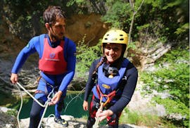 Een deelnemer aan de Extreme Canyoning bij de Cetina-rivier maakt zich klaar om over een klif naar beneden te touwen met de hulp van een ervaren gids van Adventure Dalmatia.