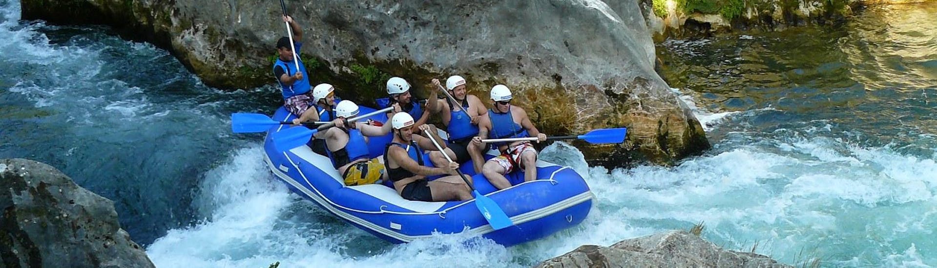 A rafting group has fun paddling down the wild waters of Cetina River on their Rafting Tour "Classic" under the guidance of an experienced instructor from Croatia Rafting.