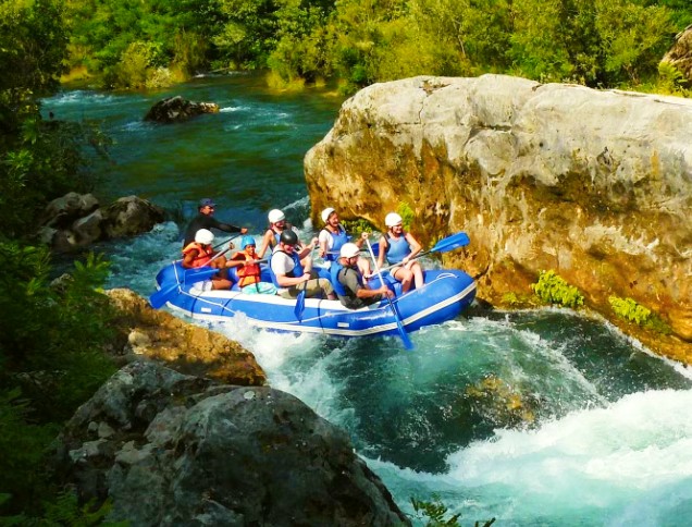 Een groep jongeren geniet van hun Rafting Tour "Classic" op de Cetina rivier samen met het ervaren team van Croatia Rafting.