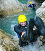 A young woman is sliding down one of the natural waterslides while canyoning in the Sušec Canyon with A2 Rafting Kobarid.