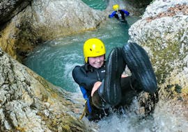 A young woman is sliding down one of the natural waterslides while canyoning in the Sušec Canyon with A2 Rafting Kobarid.