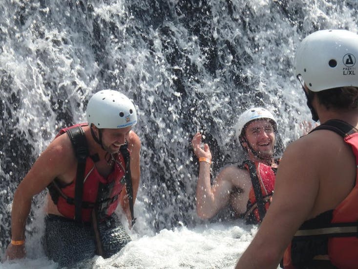 Participants having fun under the waterfall at Jerecica Gorge during canyoning for beginners from Bled with Fun Turist Bled.