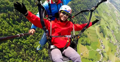 tandem-paragliding-panorama-flight-kaiserburg-flug-taxi-fun-fly-cover During the tandem paragliding panorama flight from the Kaiserburg with Flug Taxi Fun and Fly a man smiles in the camera.
