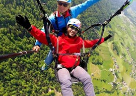 During the tandem paragliding panorama flight from the Kaiserburg with Flug Taxi Fun and Fly a man smiles in the camera.