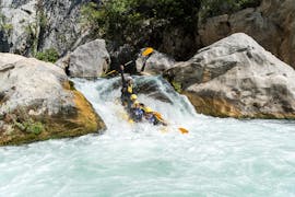 Un gruppo di partecipanti pagaiano attraverso una delle tumultuose rapide durante il rafting sul fiume Cetina con Active 365.