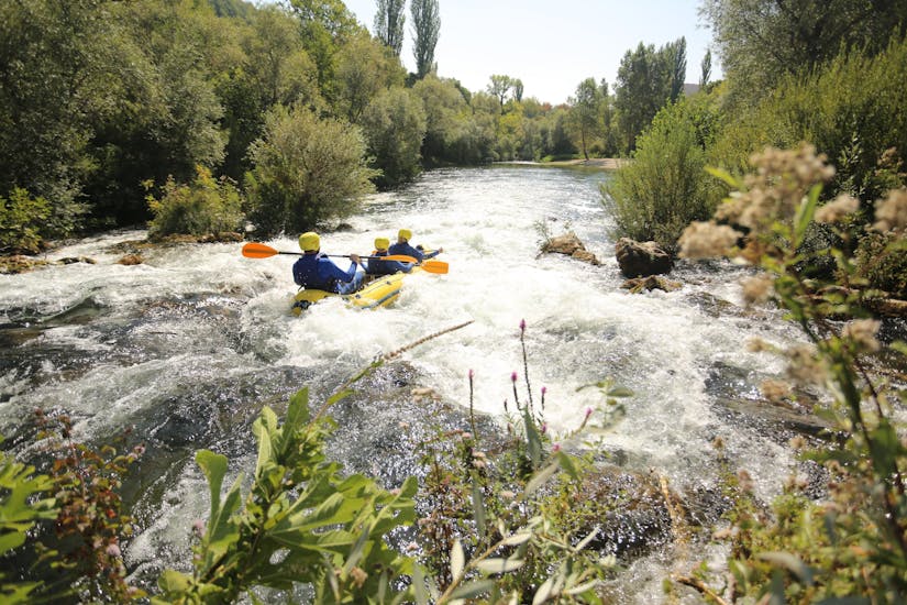 A group of people is paddling across one of the tumultuous rapids while rafting on the Cetina River with Active 365.