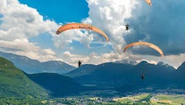 A couple of friends is flying during their Tandem Paragliding in Lake Annecy - Prestige activity with Flyeo.