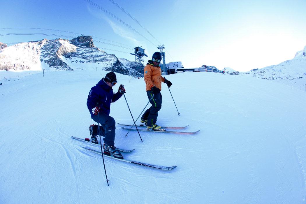 An instructors of Ski School Zenit Saas-Fee is giving tips on telemark skiing during private telemark skiing lessons.