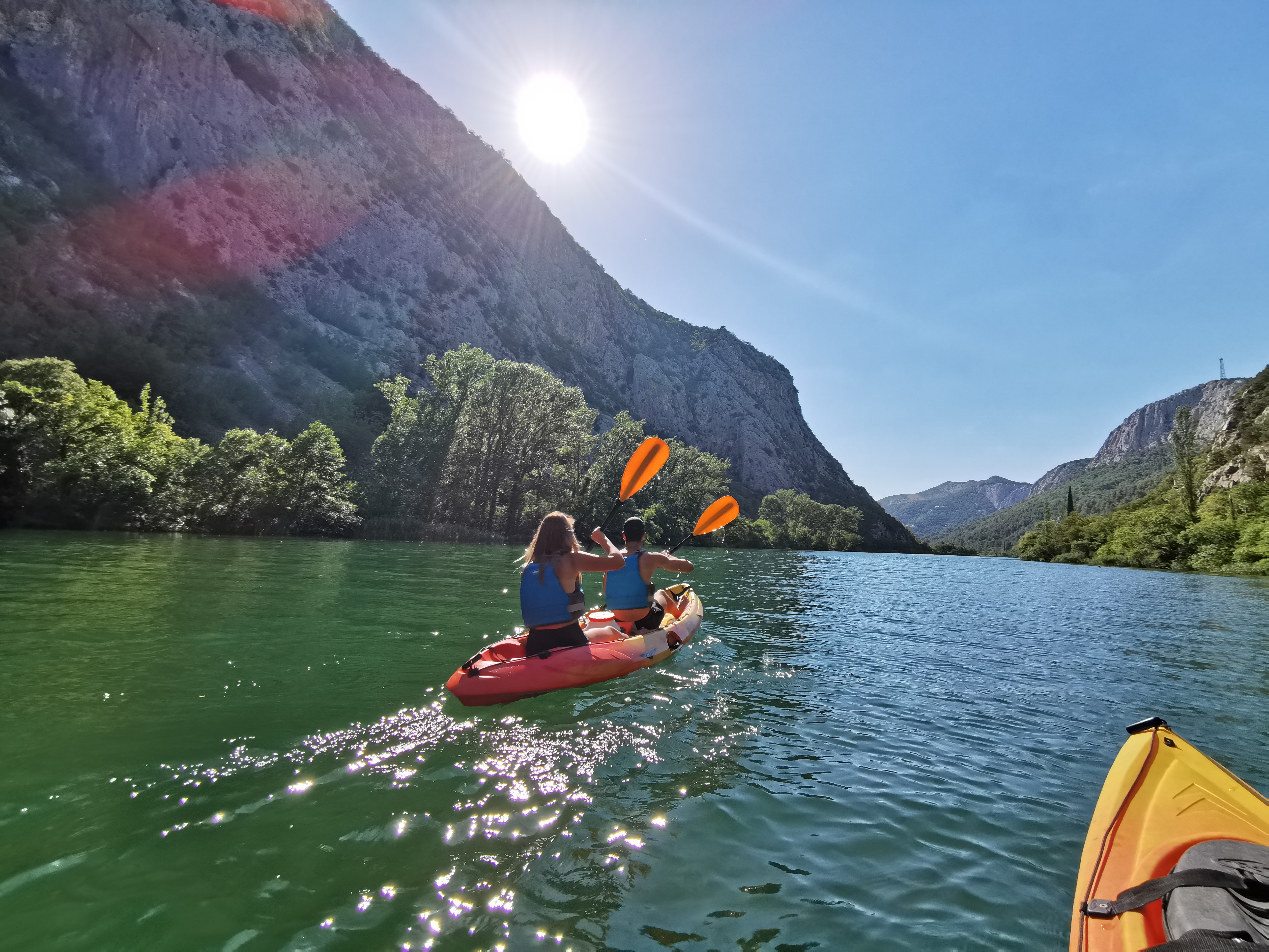 A couple is paddling through the breathtaking landscape during the Kayaking on the Cetina River to Radman Mills near Omiš with Dalmare Travel Agency Omiš.