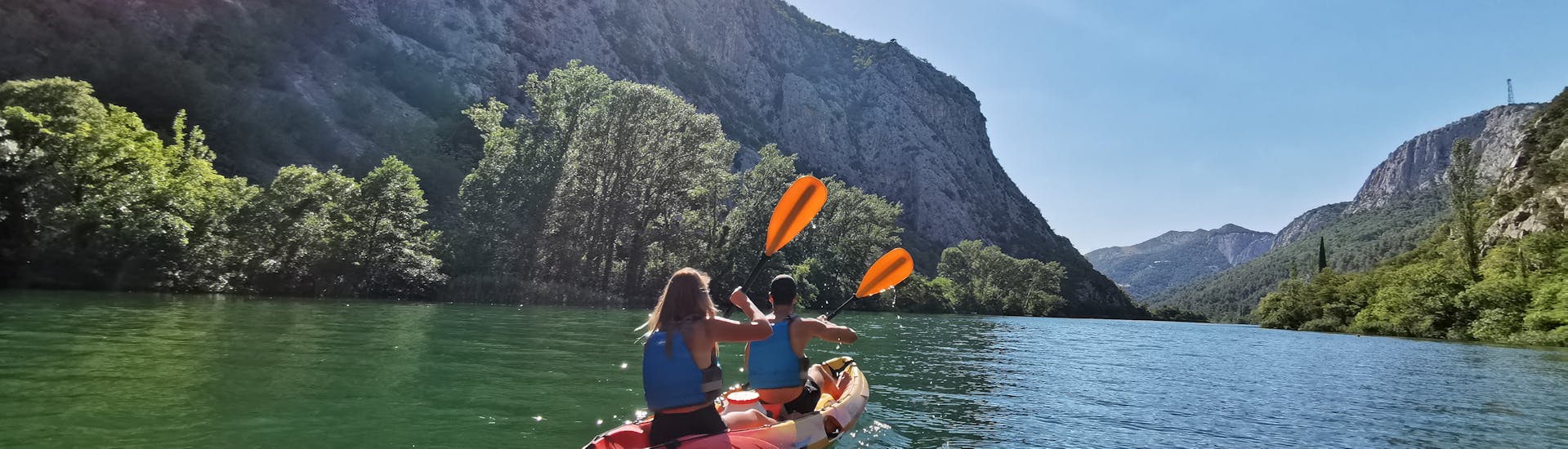 A couple is paddling through the breathtaking landscape during the Kayaking on the Cetina River to Radman Mills near Omiš with Dalmare Travel Agency Omiš.