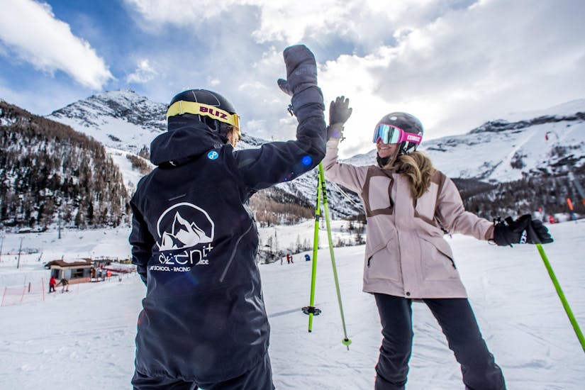 Eine Frau erlernt das Skifahren im privaten Skikurs für Erwachsene mit einem Skilehrer der Skischule Zenit Saas-Fee.