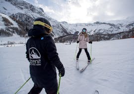 Une femme apprend à skier lors de cours particuliers de ski pour adultes avec un moniteur de l'école de ski Zenit Saas-Fee.