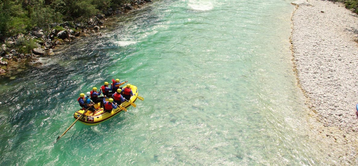Eine Gruppen an Teilnehmern fahren auf einer ruhigen Passage beim Wildwasser-Rafting im Soča-Tal - Standard-Tour mit TOP Rafting Centre.