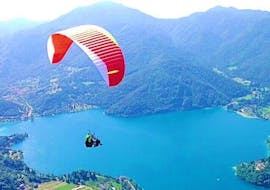 View of a tandem paragliding experience with the amazing scenery of the Ledro Lake in the background during the Tandem Paragliding at Ledro Lake with Trentino Adventures.