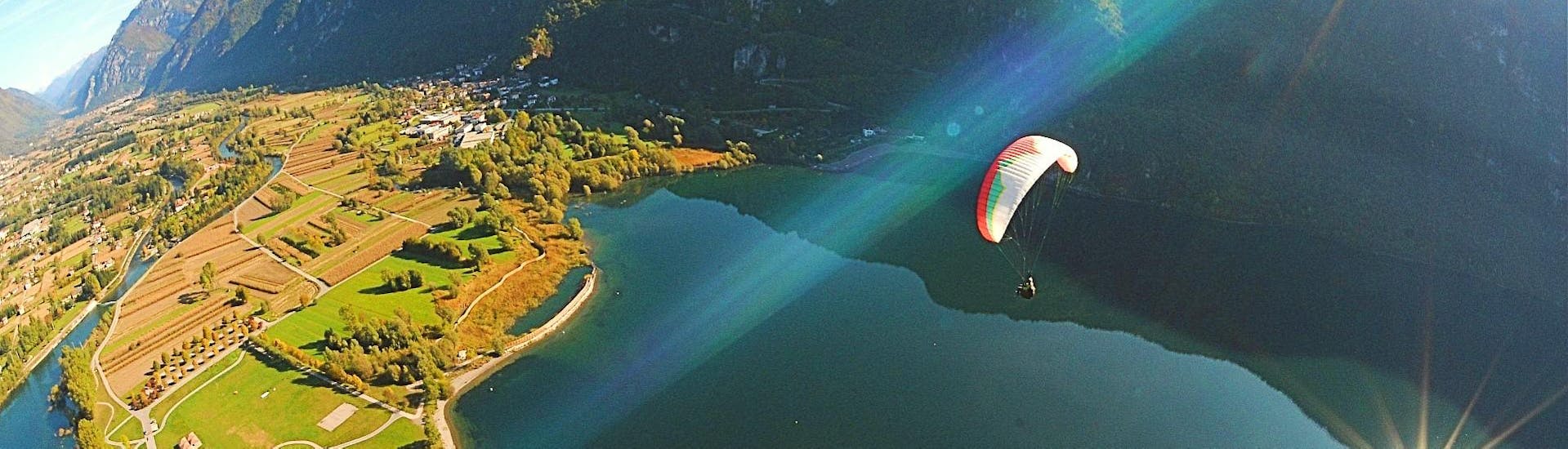 Vista di un'esperienza di parapendio in tandem con il lago di Ledro e le montagne sullo sfondo durante il Tandem Paragliding al Lago di Ledro con Trentino Adventures. 