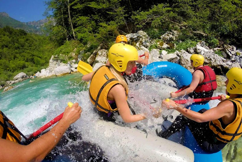 Eine Gruppe von Freunden hat Spaß auf dem Floß beim Rafting auf dem Fluss Soča in Kobarid - Action Tour mit Soča Flow Kobarid.