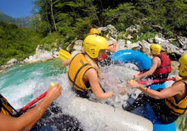 A group of friends having fun on the raft during Rafting on the Soča River in Kobarid - Action Tour with Soča Flow Kobarid.