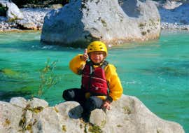 Familien-Rafting auf dem Fluss Soča in Kobarid mit Soča Flow Kobarid. Ein Junge sitzt auf einem Felsen nach der Familien-Rafting-Tour auf dem Fluss Soča in Kobarid mit Soča Flow Kobarid.