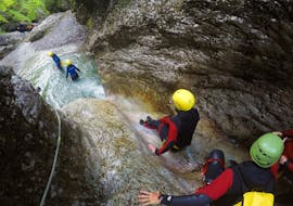 Friends on the natural slide in the gorge while canyoning in the Sušec Gorge near Kobarid for beginners with Soča Flow Kobarid.