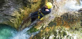 Una niña en la cascada durante el descenso de barrancos en el desfiladero de Sušec para grupos (a partir de 8 personas) con TOP Rafting Centre Bovec.
