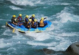 During the Rafting "First Timer Tour" in Tösen Canyon, a qualified rafting guide from WhyNot Adventures is navigating a raft with a group of enthusiasts through rapids.