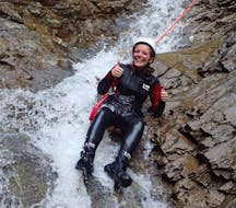 During the Canyoning "First Timer Tour" organised by WhyNot Adventures, a woman is sliding down a natural slide in the canyon Tschingels.
