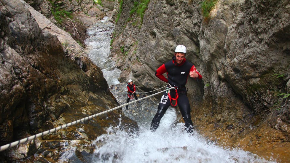 During the Canyoning "First Timer Tour" organised by WhyNot Adventures, a man is enjoying abseiling in the canyon Tschingels.