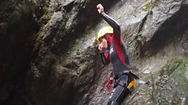 During the Canyoning "Extreme Tour" in Auerklamm, a woman is jumping into a natural pool under the supervision of a certified canyoning guide from WhyNot Adventures.