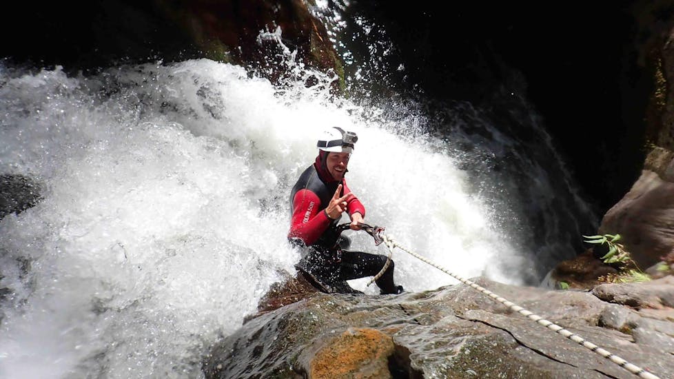 During the Canyoning "Extreme Tour" in Auerklamm, a man is abseiling a challenging part under the supervision of a qualified canyoning guide from WhyNot Adventures.