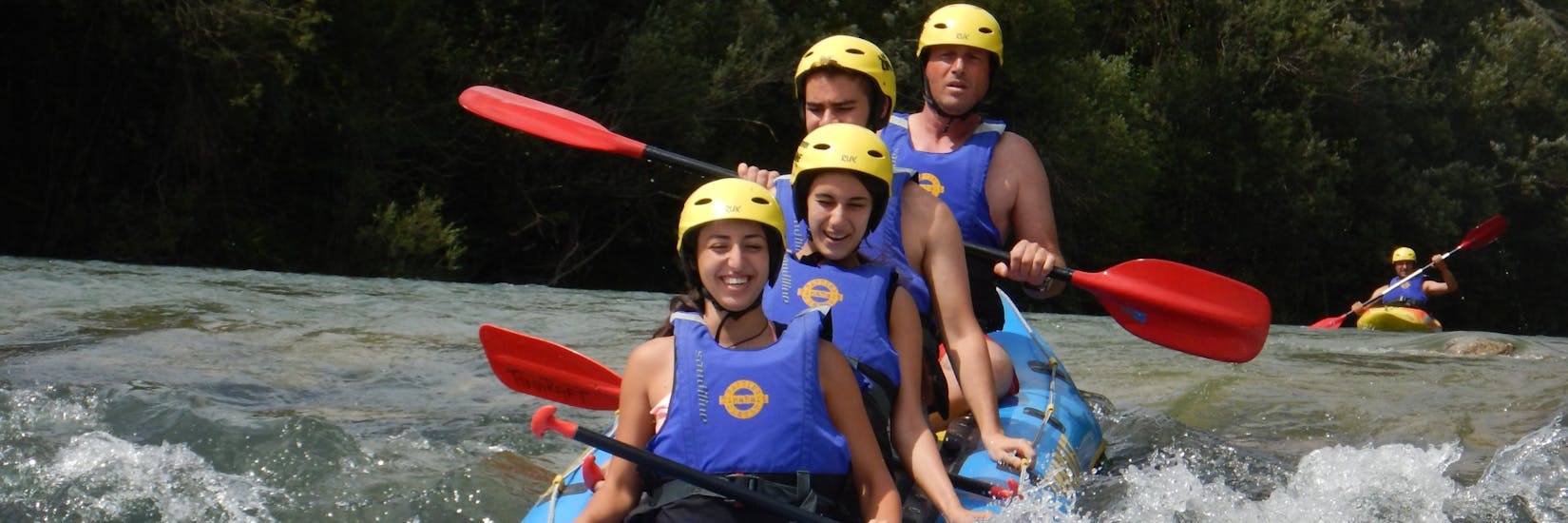 Four people having fun while Rafting with the "Mini Raft" on the Sava River with TinaRaft Radovljica.