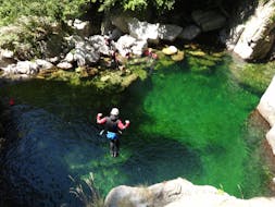 Un amateur de canyoning saute dans une piscine naturelle pendant sa sortie Canyoning "Journée Découverte" - Canyon de la Haute Borne avec Torrents & Granit.