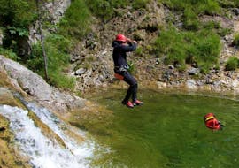 Beim Canyoning für Gruppen und Team Events (ab 6 Teilnehmern) am Sylvensteinsee mit Montevia springt ein Teilnehmer in das klare Wasser eines natürlichen Beckens.