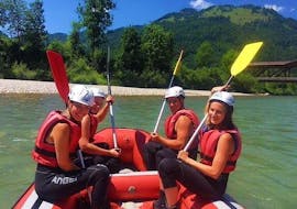 A group sitting in a raft on the river during their Rafting on the Kitzbüheler Ache for Families with Der Guide Brixtental. 