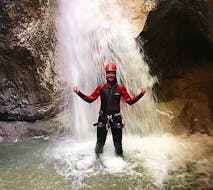 A woman standing underneath a waterfall during Rafting & Canyoning on the Kitzbüheler Ache with Der Guide Brixental.