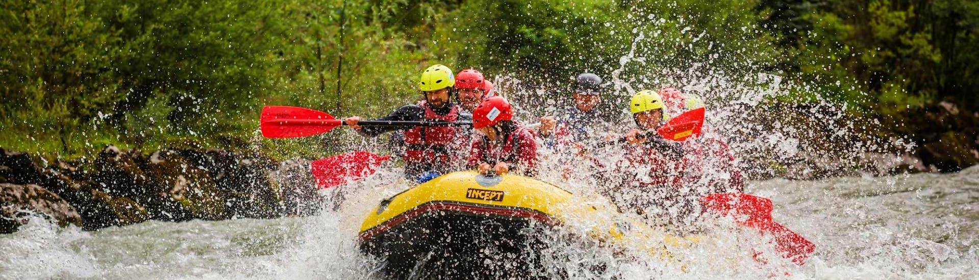 Tijdens hun sportieve rafting op de Salzach rivier met Torrent Outdoor  Experience, peddelt een groep rafters door een sterke stroomversnelling op de rivier.
