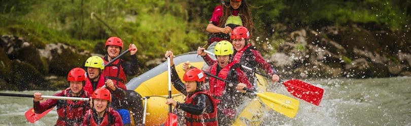 Een groep mensen die de golven van de Salzach rivier berijden op hun sportieve rafting tour met Torrent Outdoor Experience.