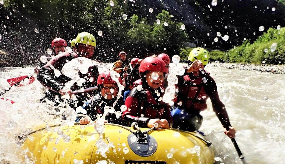 Een gezin geniet van het klotsende water van de rivier tijdens hun Fun  Rafting op de Salzach rivier met Torrent Outdoor Experience.