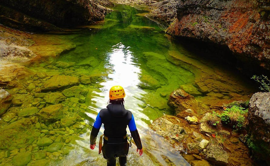 Ein Teilnehmer des Abenteuer Canyoning in der Strubklamm mit Torrent Outdoor Experience macht sich bereit, durch das smaragdgrüne Wasser der Schlucht zu schwimmen.