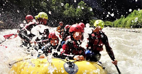 Canyoning im Almbach & Rafting auf der Salzach - Patschnass mit Torrent Outdoor Experience Golling Eine Familie hat Spaß beim Paddeln durch spritzige Stromschnellen während ihrer Rafting-Tour, die Teil des "Canyoning in Almbach & Rafting auf der Salzach - Patschnass" mit Torrent Outdoor Experience ist.