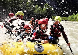 Een familie heeft plezier tijdens het peddelen door klaterende stroomversnellingen tijdens hun rafting tour die deel uitmaakt van de "Canyoning in Almbach & Rafting op de Salzach - Soaking Wet" met Torrent Outdoor Experience.