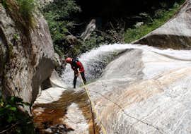 Canyoning in the Sorba with Eddyline - The River Experience Valsesia A man is going through a waterfall during his climb in the Canyoning in the Sorba with Eddyline - The River Experience Valsesia.